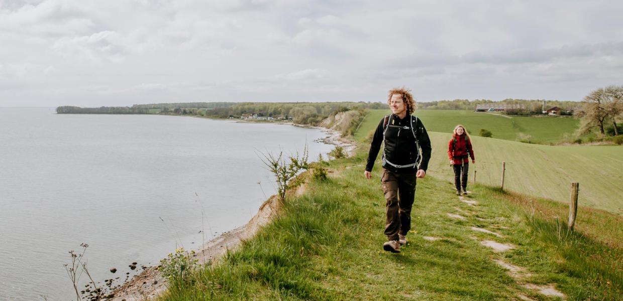Paar wandelt op de Gendarmstien met uitzicht op Flensburg Fjord